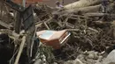 Sebuah mobil tergeletak di tengah puing-puing yang ditinggalkan oleh banjir dan tanah longsor yang dipicu hujan lebat di Tovar, negara bagian Merida, Venezuela, Kamis (26/8/2021). Sedikitnya 20 orang tewas akibat hujan lebat banjir yang terjadi pada Rabu, 25 Agustus. (AP Photo/Luis Bustos)