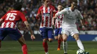 Bomber Real Madrid, Cristiano Ronaldo, berduel dengan striker Atletico Madrid, Antonie Griezmann, dalam laga yang berlangsung di Santiago Bernabeu, Minggu (8/4/2018). (AP Photo/Francisco Seco)