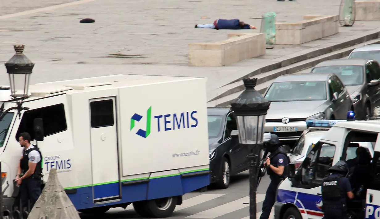 Seorang pria tergeletak di jalan setelah ditembak oleh pihak kepolisian di luar Katedral Notre-Dame, Paris, Selasa (6/6). Pria itu dilaporkan mencoba menyerang anggota polisi dengan menggunakan palu dan membawa sebilah pisau. (David Metreau via AP)