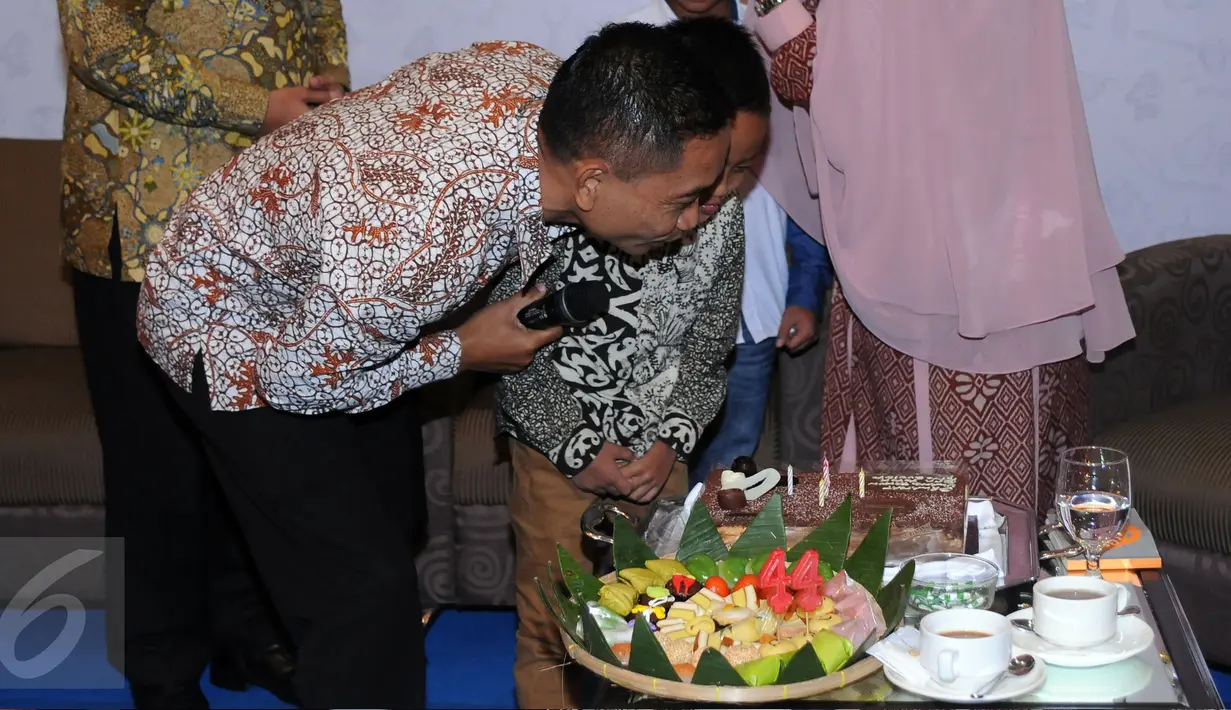 Bupati Batang, Yoyok Riyo Sudibyo bersama sang anak meniup lilin saat mendapat kejutan dari istri dan kedua anaknya usai berbicara pada seminar Kekuatan Perempuan Inspirasi Perubahan di Jakarta, Sabtu (23/4/2016). (Liputan6.com/Helmi Fithriansyah)