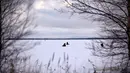 Sejumlah pria memancing di tengah laut Bothnia yang sedang membeku di Vaasa, Finlandia, Rabu (27/12). Memancing di laut beku merupakan hal yang ditunggu-tunggu oleh sebagian warga setempat. (OLIVIER MORIN / AFP)