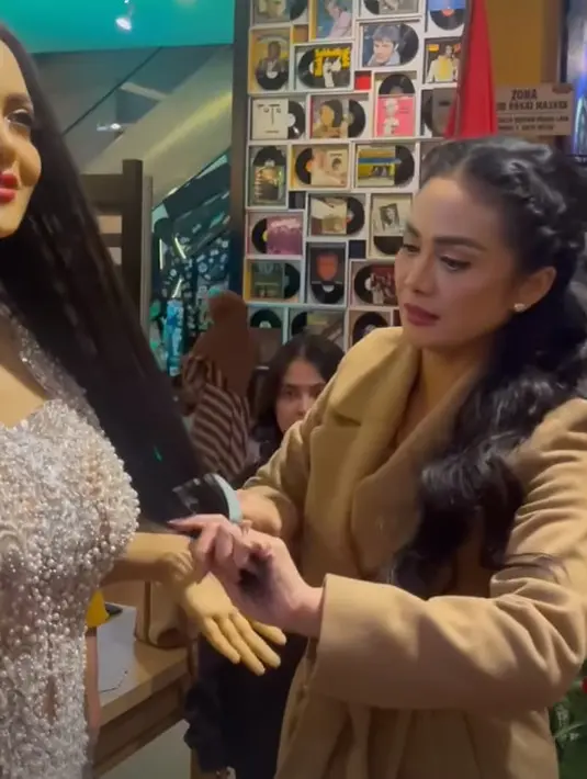 Krisdayanti pun turun tangan langsung mendandani patung manekin yang menyerupai dirinya. Ia pun tak ragu menyisiri rambut panjang patung tersebut agar terlihat cantik paripurna. [@krisdayantilemos]