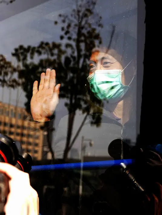Pasien virus corona yang pulih melambaikan tangan kepada pekerja medis ketika meninggalkan rumah sakit sementara Wuchang di Wuhan, Hubei, China (10/3/2020). Kelompok terakhir yang terdiri dari 49 pasien meninggalkan rumah sakit pada Selasa (10/3) pukul 15.30 waktu setempat. (Xinhua/Wang Yuguo)