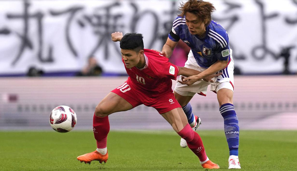 Pemain Vietnam, Pham Tuan Hai (kiri) berebut bola dengan pemain Jepang, Kou Itakura pada laga Grup D Piala Asia 2023 di Al Thumama Stadium, Qatar, Minggu (14/01/2024). (AP Photo/Thanassis Stavrakis)