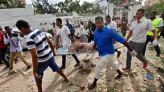 Sejumlah pria membawa jenazah korban serangan bom yang terjadi di sebuah restoran di Mogadishu, Somalia, Kamis (15/6). (AP Photo)