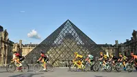 Pebalap Kolombia Egan Bernal (tengah) melewati museum piramida Louvre saat mengikuti Tour de France 2019, Paris, Prancis, Minggu (28/7/2019 ). Tour de France 2019 dimulai dari Rambouillet dan berakhir di Paris. (Julien de Rosa/Pool Photo via AP)