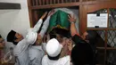 Sejumlah orang saat memasukkan keranda jenazah Ali Mustafa Yaqub  ke rumah duka di Pisangan Barat, Ciputat, Tangsel, Kamis (28/4). Mantan Imam Masjid Istiqlal itu wafat di usia 64 tahun karena sakit. (Liputan6.com/Helmi Afandi)