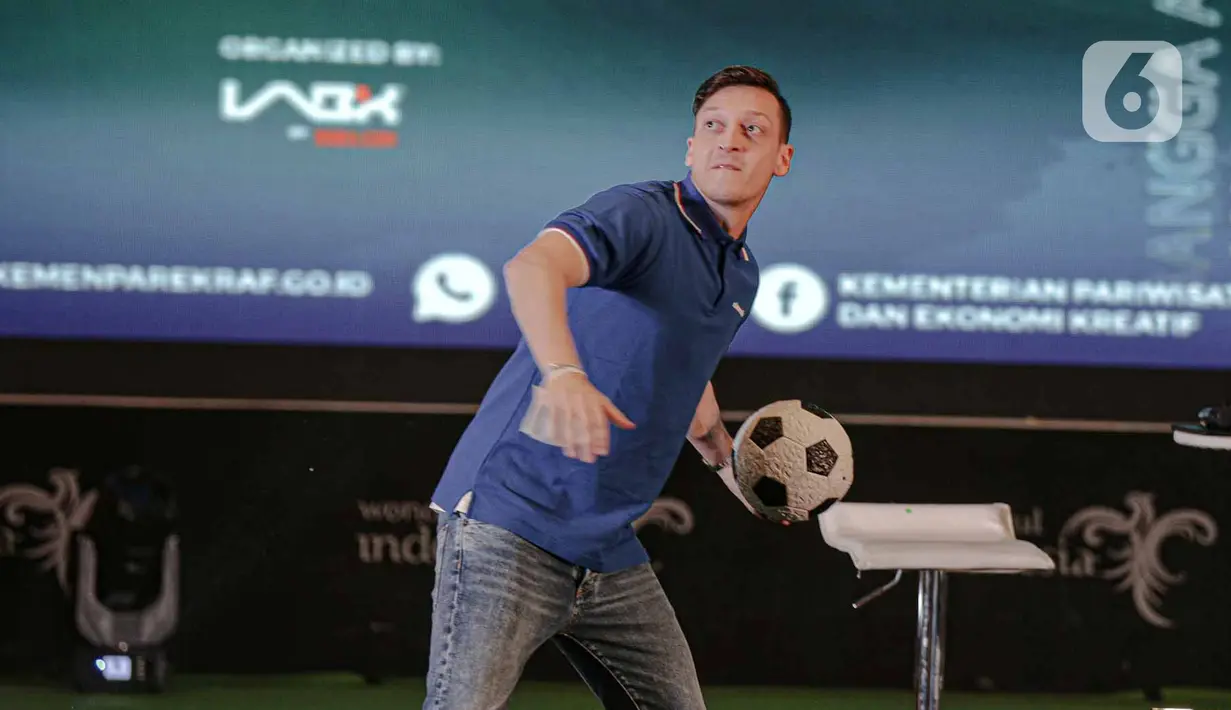 Pemain sepak bola dunia, Mesut Ozil, melempar bola saat konferensi pers di kantor Kementerian dan Pariwisata dan Ekonomi Kreatif (Kemenparekraf), Jakarta, Rabu (25/5/2022). Dalam kunjungan ke Indonesia ini, Mesut Ozil juga bakal melakukan kegiatan pelatihan sejumlah anak-anak kurang mampu yang memiliki talenta di bidang sepak bola. (Liputan6.com/Faizal Fanani)
