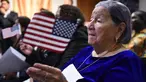 Maria Valles Bonilla melambaikan bendera AS selama upacara naturalisasi di kantor Citizenship and Immigration Services AS (USCIS) di Fairfax, Virginia, 6 November 2018. Nenek 106 tahun itu resmi menjadi warga negara Amerika Serikat. (MANDEL NGAN/AFP)