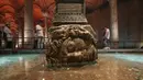 Pengunjung berjalan melewati kolom Medusa di Basilika Cistern era Bizantium di Istanbul, Turki, Rabu, 27 Juli 2022. Tidak jelas dari mana dua kepala Medusa ini berasal dan kapan dibawa masuk dan dipasang di Basilica Cistern. (AP Photo/Emrah Gurel)