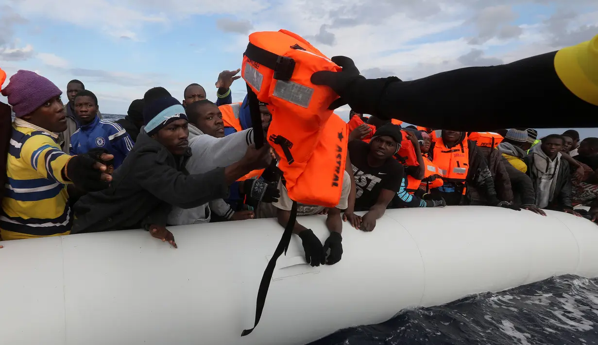 Penjaga pantai Spanyol memberikan plampung kepada para imigran Afrika di tengah Laut Mediterania, sekitar 36 mil laut dari lepas pantai Libya (2/2). (Reuters/Yannis Behrakis)