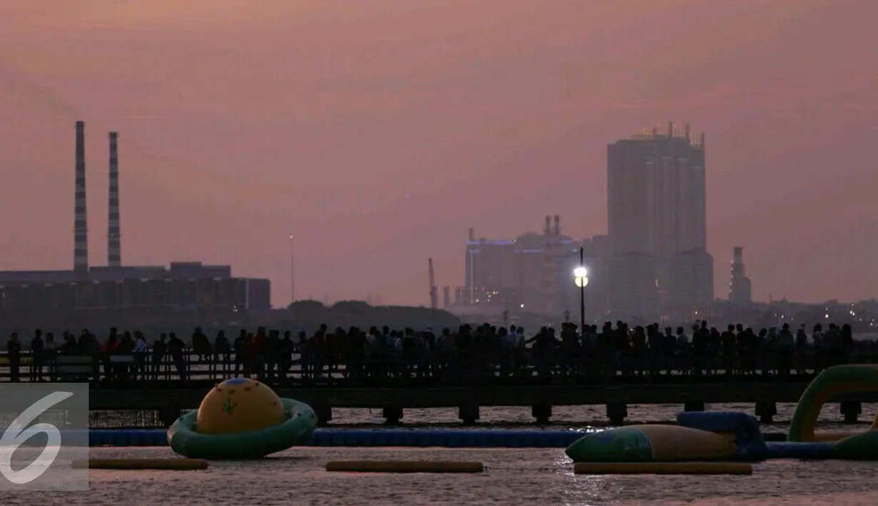 Sejumlah pengunjung memadati kawasan Ancol untuk menikmati matahari terbenam,  Jakarta, Sabtu (31/12). Tak hanya menikmati indahnya senja, selain itu banyak pula pengunjung yang bermain pasir dan berenang. (Liputan6.com/Angga Yuniar)