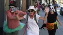 Para peserta berdandan seperti badut mengejar pejalan kaki selama 'Running of the Clowns' di Pasadena, California pada 21 Oktober 2018. Lari dikejar kawanan badut ini merupakan parodi yang mengolok-olok lomba dikejar banteng di Spanyol. (Mark RALSTON/AFP)