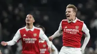 William Saliba dari Arsenal, kiri, dan Martin Odegaard dari Arsenal merayakan kemenangan mereka pada pertandingan sepak bola Liga Premier Inggris antara Tottenham Hotspur dan Arsenal di Stadion Tottenham Hotspur di London, Inggris, Minggu, 15 Januari 2023. (AP Photo/Frank Augstein)