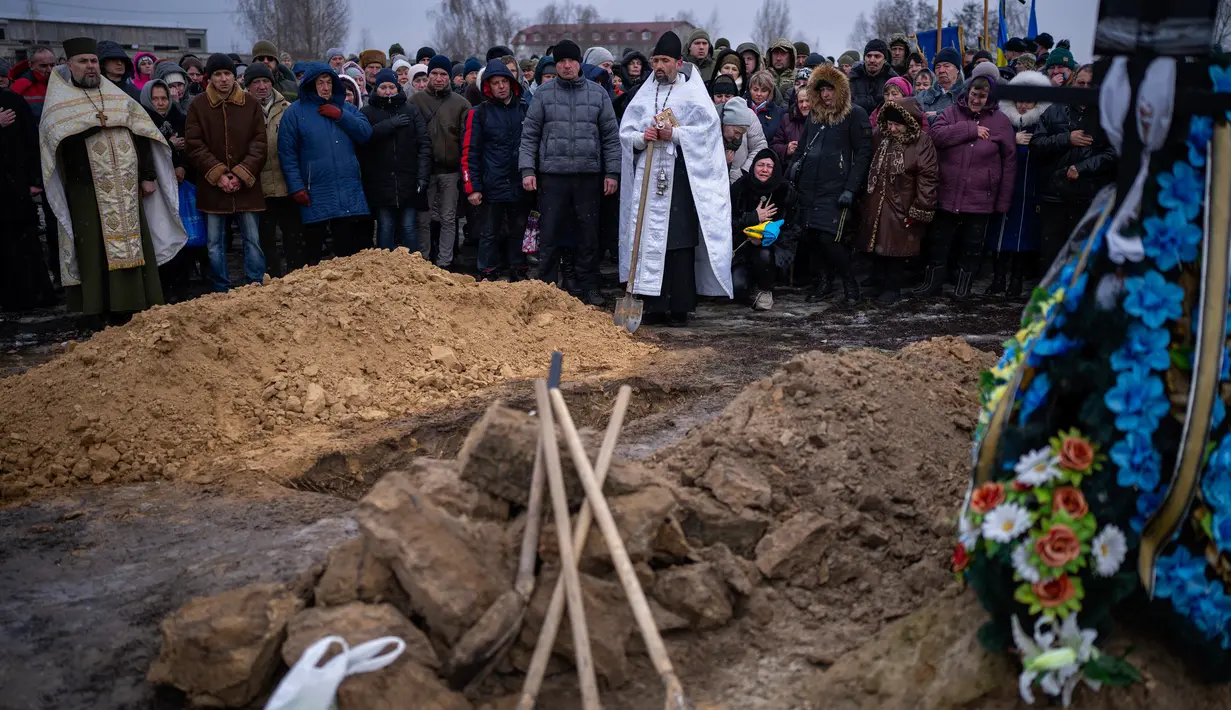 Para pelayat bereaksi di samping jenazah Oleksandr Maksymenko (38) saat pemakamannya di kampung halamannya di Kniazhychi, sebelah timur Kyiv, Ukraina, 13 Februari 2023. Oleksandr Maksymenko, seorang warga sipil yang menjadi sukarelawan di angkatan bersenjata Ukraina, tewas dalam pertempuran di daerah Bakhmut. (AP Photo/Emilio Morenatti)