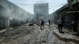 Orang-orang berkumpul melihat kondisi masjid yang terdapat makam Sayid Muhammad bin Ali al-Hadi di Balad usai terkena serangan bom bunuh diri, Baghdad, Irak (8/7). Dikabarkan 30 orang tewas dalam peristiwa tersebut. (REUTERS / Thaier Al-Sudani)