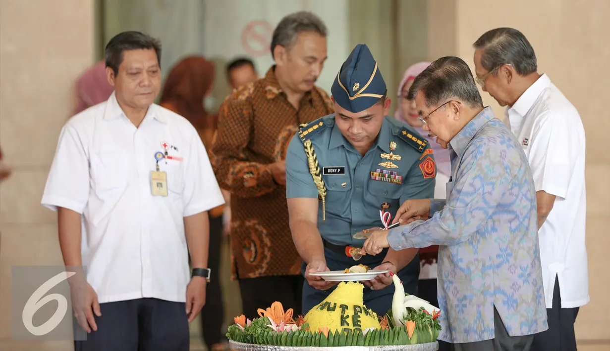 Wakil Presiden Jusuf Kalla memotong nasi tumpeng saat menghadiri HUT ke-70 Palang Merah Indonesia (PMI) di Museum Nasional, Jakarta, Kamis (17/9/2015). (Liputan6.com/Faizal Fanani)