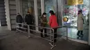 Petugas menyemprotkan sanitizer ke pengunjung di dalam Pyongyang Department Store No. 1, Korea Utara (28/12/2020). Meski Korea Utara melaporkan nol kasus Covid-19, pemerintahan Pyongyang tetap menerapkan standar protokol kesehatan guna mencegah penyebaran Covid-19. (AFP/Kim Won Jin)