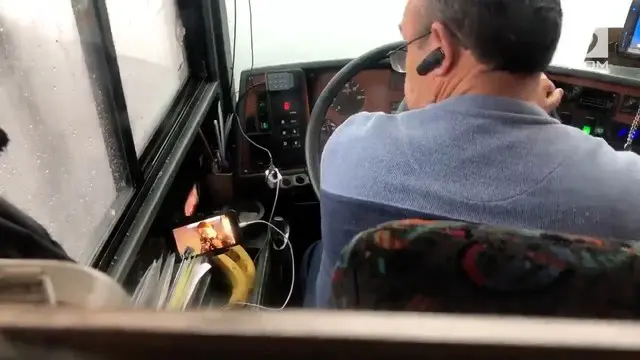Rekaman seorang sopir bus wisata yang mengemudi sambil menonton video di ponsel.