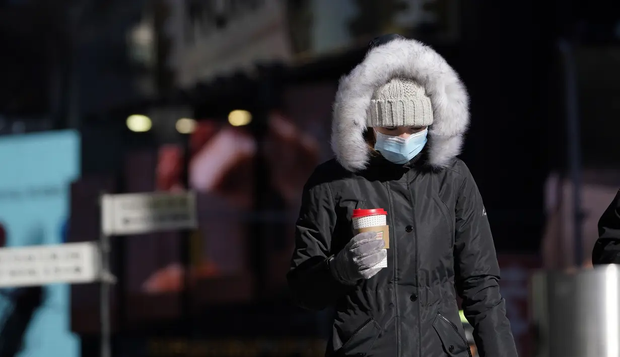 Pejalan kaki mengenakan mantel tebal melawan dingin di New York, Selasa (11/1/2022). Massa udara kutub utara menyapu timur laut AS, membawa suhu di bawah nol yang menusuk tulang dan menutup sekolah di seluruh wilayah untuk kedua kalinya dalam waktu kurang dari seminggu. (AP Photo/Seth Wenig)