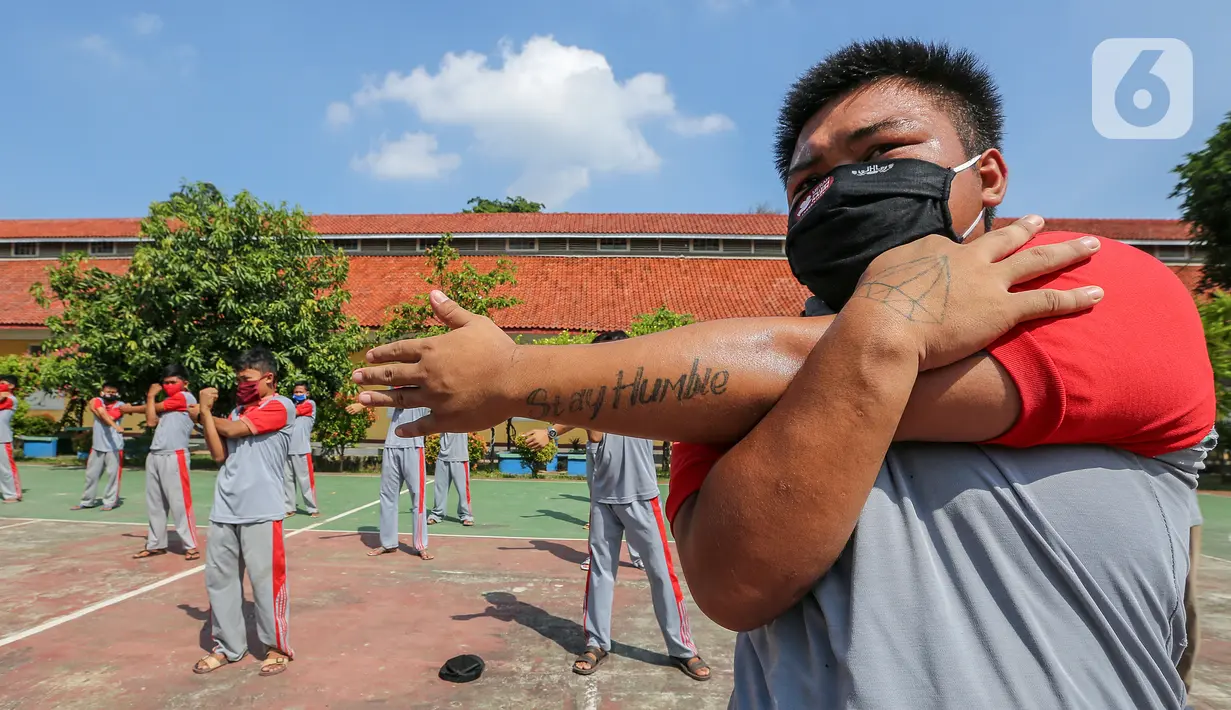 Anak binaan melakukan peregangan otot atau stretching di lapangan Lembaga Pembinaan Khusus Anak (LPKA) Klas 1 Tangerang, Banten, Sabtu (30/5/2020). Stretching dengan physical distancing selama pandemi Covid-19 meningkatkan sistem imunitas tubuh terjaga dengan baik (Liputan6.com/Fery Pradolo)