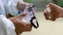 Petugas medis menyemprotkan desinfektan ke kacamata menyusul wabah virus corona di Wuhan, Provinsi Hubei, China, Minggu (26/1/2020). Sebuah studi menemukan setidaknya 40 pekerja perawat kesehatan terinfeksi virus Corona oleh pasien di satu rumah sakit di Wuhan pada Januari lalu. (Chinatopix via AP)