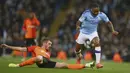 Penyerang Manchester City, Raheem Sterling berusaha melewati bek Shakhtar Donetsk, Serhiy Kryvtsov pada pertandingan Grup C Liga Champions di Stadion Etihad, Inggris (26/11/2019). Manchester City bermain imbang 1-1 atas Shakhtar Donetsk. (AP Photo/Dave Thompson)