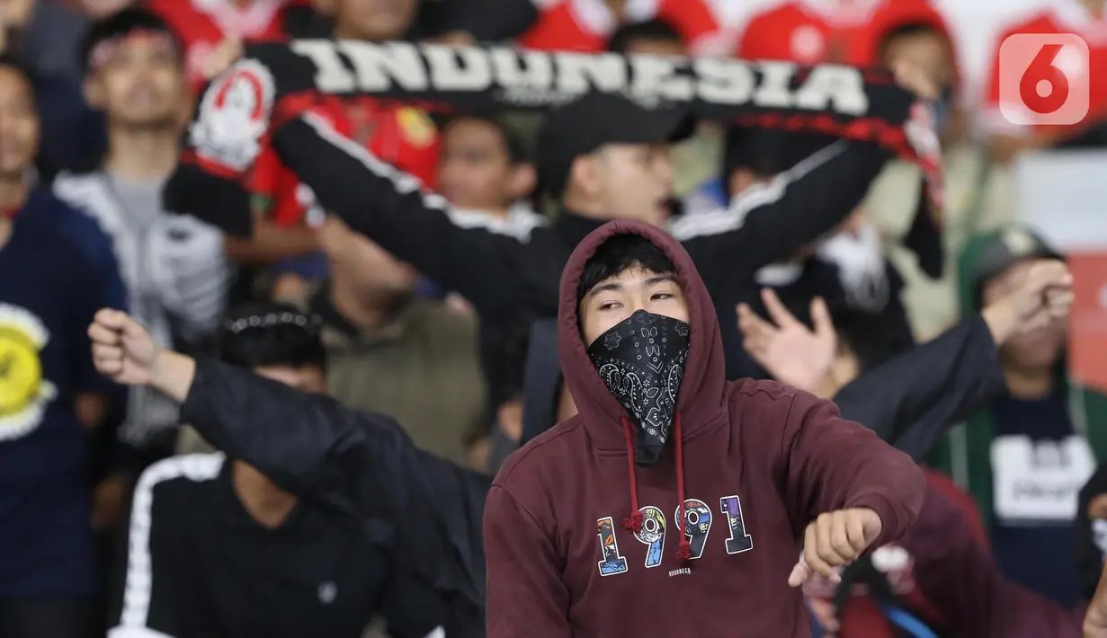 Suporter timnas Indonesia membentang syal dan bernyanyi usai menyaksikan laga timnas Indonesia melawan Thailand pada lanjutan kualifikasi Grup A Piala AFF 2022 di Stadion Utama Gelora Bung Karno, Jakarta, Kamis (29/12/2022). Laga berakhir imbang 1-1. (Liputan6.com/Helmi Fithriansyah)
