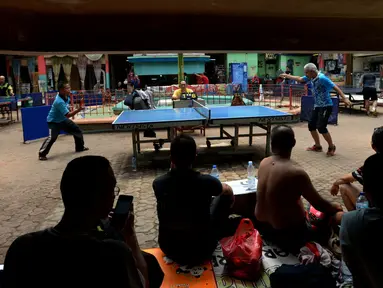 Petenis melakukan servis ke arah lawannya saat kejuaraan Bintikers Cup Tenis Meja di Pasar Grogol, Jakarta, Sabtu (14/12/2019). Turnamen Bintikers Cup Tenis Meja diikuti 125 orang yang merupakan perwakilan pedagang pasar se-Jabodetak dan luar Jakarta seperti Surabaya. (merdeka.com/Imam Buhori)