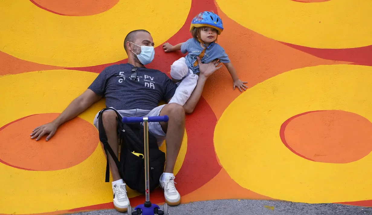 Manny Lopez dan putranya Matthew (2) beristirahat saat mencoba Haulover Beach Park Skate Park dan Pump Track di Miami Beach, Florida, Amerika Serikat, 19 Oktober 2020. Berdasarkan data Worldometers pada 19 Oktober 2020, jumlah kasus COVID-19 di AS sebanyak 8.387.799. (AP Photo/Wilfredo Lee)