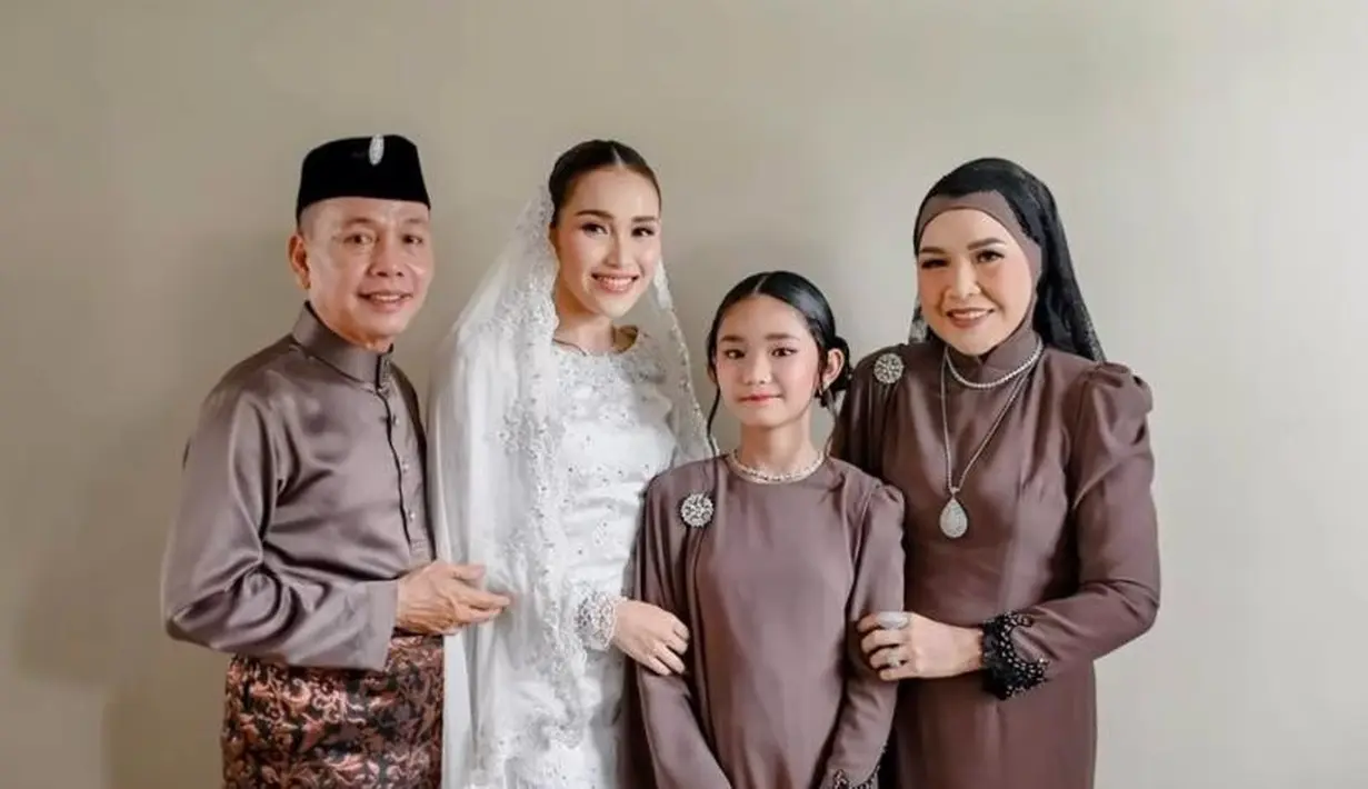 Berbeda dengan Ayu Ting Ting, Bilqis mengenakan baju kurung warna ungu tua yang senada dengan Ayah Rozak dan Umi Kalsum. [@mom_ayting92_]