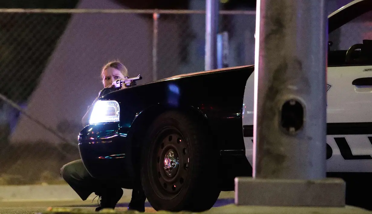 Polisi bersenjata berjaga saat terjadi penembakan di Las Vegas, Nevada (1/10). Penembakan yang terjadi sekitar pukul 01.45 pagi itu dilaporkan berlokasi tak jauh dari markas besar polisi di Lawrence. (AP Photo/John Locher)