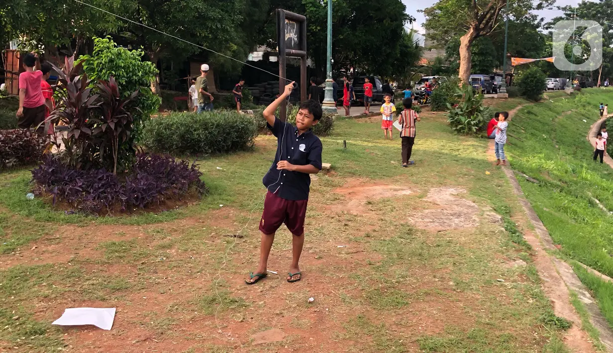 Anak-anak bermain di sekitar bantaran Kanal Banjir Timur (KBT), kawasan Cipinang Muara, Jakarta, Selasa (16/6/2020). Selama masa PSBB transisi, aktivitas di kawasan tersebut mulai kembali ramai. (Liputan6.com/Immanuel Antonius)