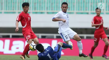 Pemain depan Uzbekistan, Narzuliaev Doniyorjon (kedua kanan) berebut bola dengan kiper Korea Utara Kim Yu II pada laga perdana PSSI Anniversary 2018 di Stadion Pakansari, Kab Bogor, Jumat (27/4). Laga berakhir imbang 2-2. (Liputan6.com/Helmi Fithriansyah)