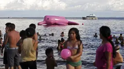 Para wisatawan pantai Ponta Negra tampak mengamati lumba-lumba raksasa pink tersebut, Manaus, Minggu (27/7/14). (REUTERS/Bruno Kelly)