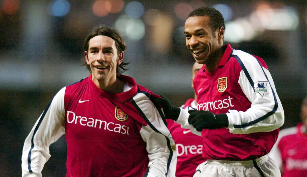 Thierry Henry dan Robert Pires - Duet legendaris Arsenal ini merupakan salah satu kunci kejayaan The Gunners era Arsene Wenger. Kala itu keduanya mampu 29 gol untuk klub Meriam London. (AFP/Adrian Dennis)