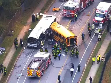 Petugas personel darurat dikerahkan ke lokasi kecelakaan sebuah bus komuter dan bus sekolah yang mengalami tabrakan di Baltimore, Maryland, Selasa (1/11). Sebanyak enam orang tewas dan sepuluh lainnya terluka akibat insiden itu. (WBAL-TV via AP)