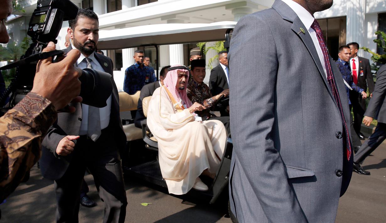 Sejumlah pengawal Raja Salman terlihat menjaga ketat mobil yang dikemudikan Jokowi saat keliling halaman Istana Merdeka, Jakarta, Kamis (2/3). (AFP Photo/ Pool/ ADI WEDA)
