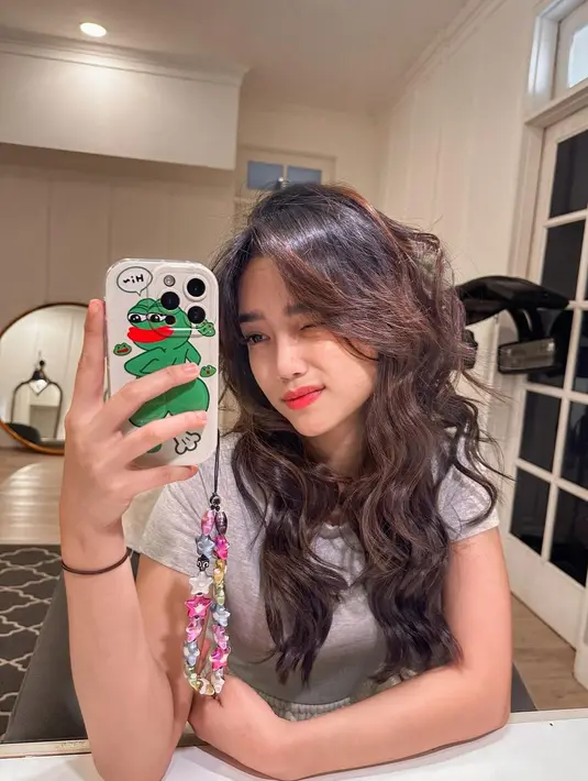 Fuji pamer mirror selfienya yang cantik. Kembali berpose mengedipkan satu matanya, Fuji menampakkan gaya rambut panjangnya yang terbaru, diikal loose dan ia merias wajahnya secara minimalis dengan pulasan lipstik bernuansa oranye yang menyatu sempurna dengan tone kulitnya. [Foto: Instagram/fuji_an]