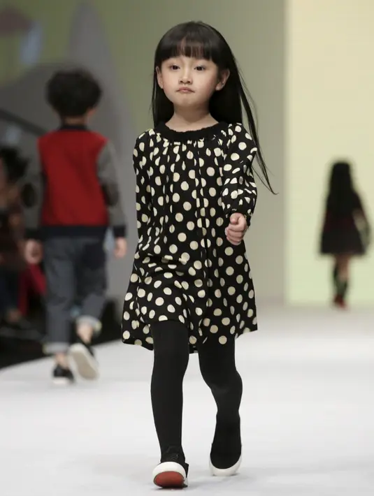 Seorang anak saat membawakan busana koleksi M.latin di Cina Fashion Week S/S 2016 di Beijing, Cina, Rabu (28/10/2015) . Acara ini berlangsung dari 25-31 Oktober 2015. (REUTERS/Jason Lee)