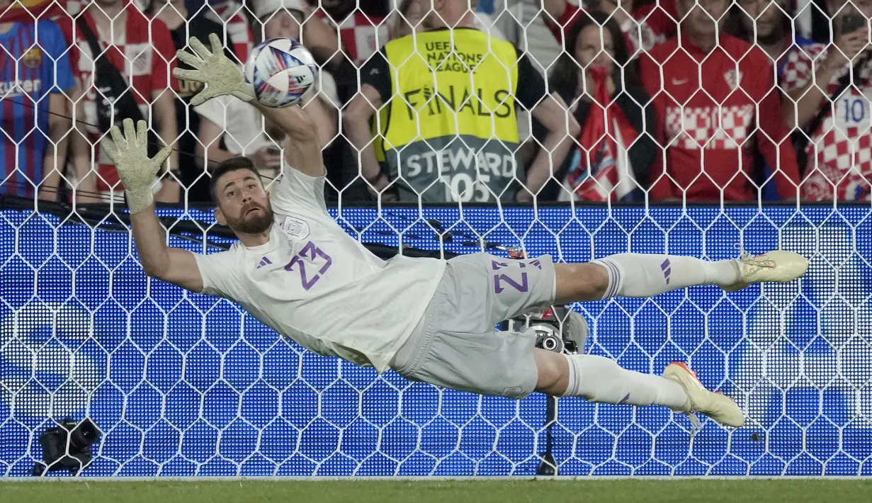 Kiper Timnas Spanyol, Unai Simon berhasil menepis eksekusi penalti striker Timnas Kroasia, Bruno Petkovic saat babak adu penalti pada laga final UEFA Nations League 2022/2023 di De Kuip Stadium, Rotterdam, Senin (19/6/2023) dini hari WIB. (AP Photo/Peter Dejong)
