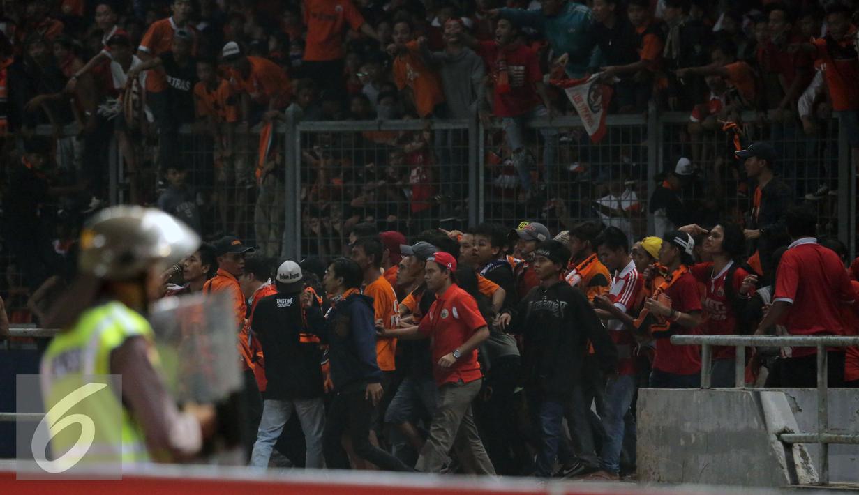 Suporter merangsek masuk lapangan saat laga Persija melawan Sriwijaya FC pada lanjutan Torabika Soccer Championship presented by IM3 Ooredoo di Stadion GBK Jakarta, Jumat (24/6).Laga dihentikan di menit 81. (Liputan6.com/Helmi Fithriansyah)
