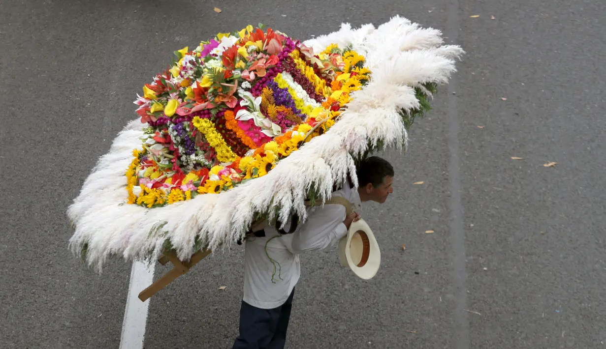 Seorang pria memanggul rangkaian bunga saat digelarnya festival bunga tahunan di Medellin, Kolombia, Minggu (9/8/2015). Festival yang dikenal dengan nama Silleteros Parade ini telah dilangsungkan sejak 1957. (REUTERS/Fredy Builes)