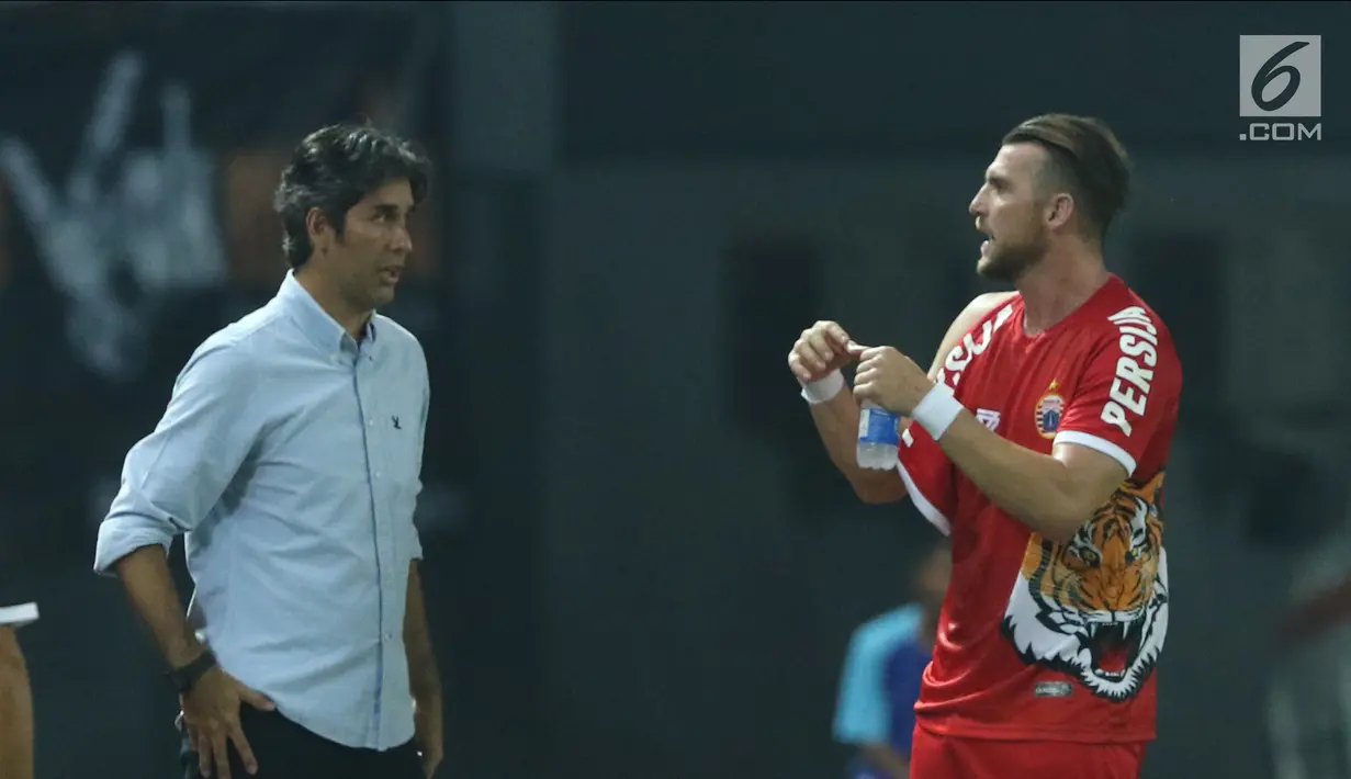 Pemain depan Persija, Marko Simic (kanan) berbincang dengan pelatih Stefano Cugurrausai kaus yang dikenakan robek pada bagian lengan saat laga melawan Selangor FA di Stadion Patriot Candrabhaga, Bekasi, Kamis (6/9). (Liputan6.com/Helmi Fithriansyah)