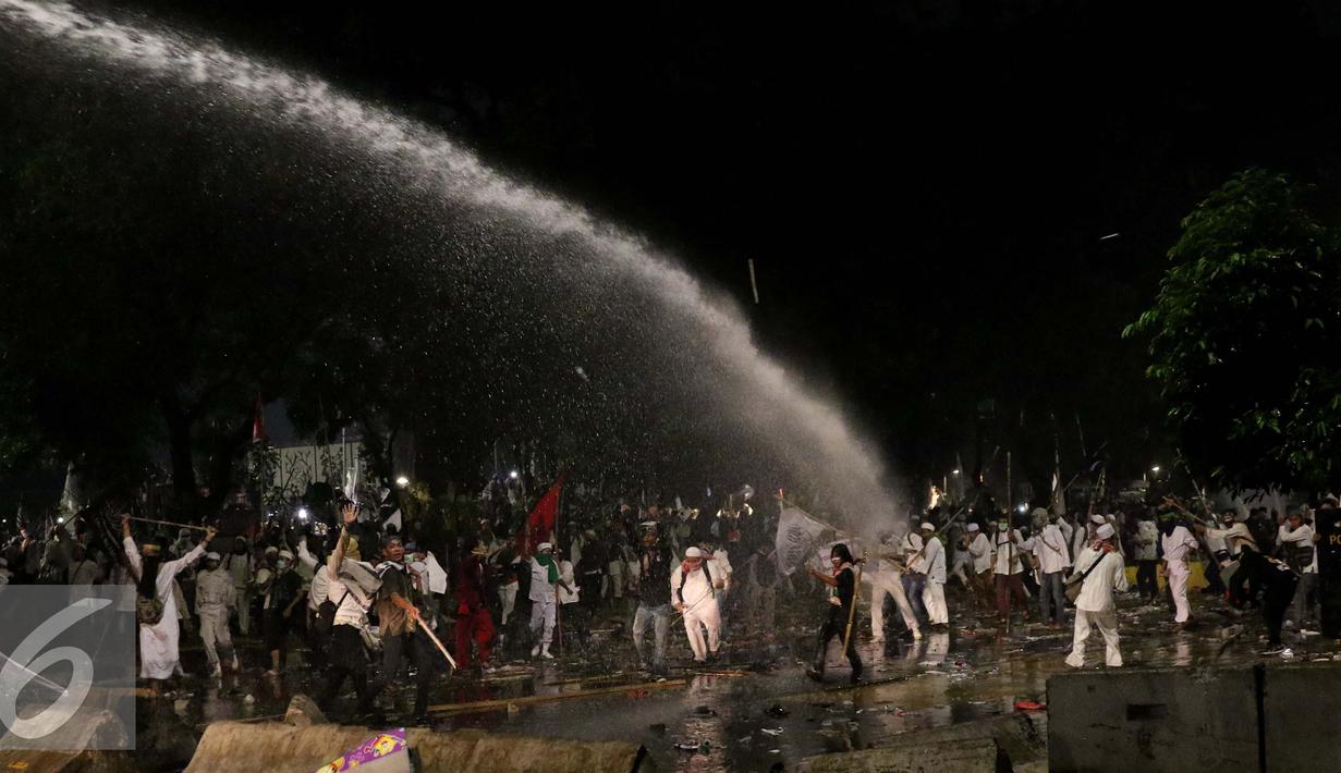 Polisi menembakkan air ke arah pendemo saat bentrok di Jakarta, Jumat (4/11). Diduga bentrok terjadi saat massa HMI menyerang polisi dan polisi membalasnya dengan melempar gas air mata. (Liputan6.com/Gempur M Surya)