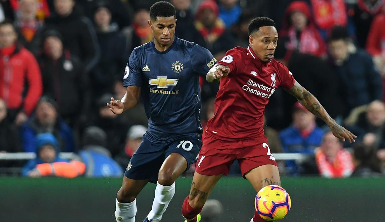 Bek Liverpool, Nathaniel Clyne, berebut bola dengan striker Manchester United, Marcus Rashford, pada laga Premier League di Stadion Anfield, Liverpool, Minggu (16/12). Liverpool menang 3-1 atas MU. (AFP/Paul Ellis)