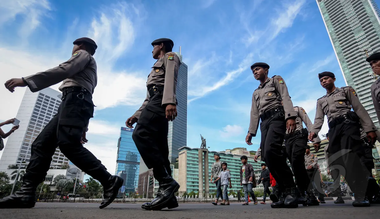 Sejumlah personil kepolisian saat melakukan aksi simulasi pengamanan dalam peringatan Hari Buruh Internasional atau biasa disebut May Day yang jatuh pada 1 Mei, di Bundaran HI, Jakarta, Jumat (30/4/2015). (Liputan6.com/Faizal Fanani)