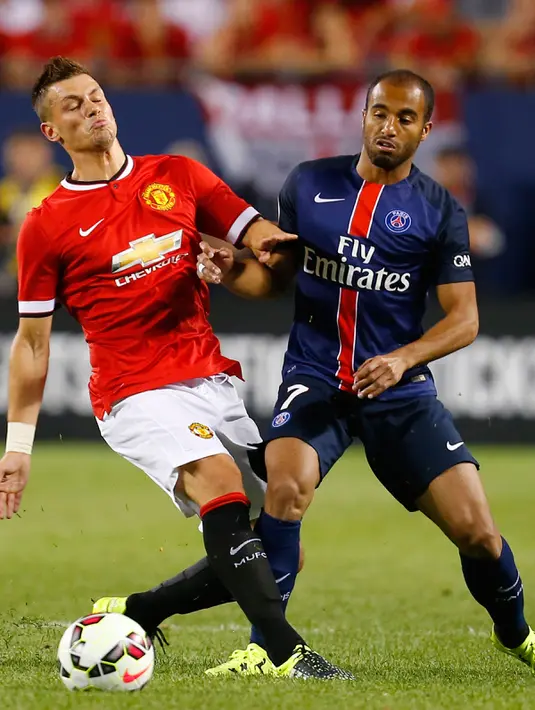Gelandang baru MU Morgan Schneiderlin saat berebut bola dengan Gelandang PSG Luca Moura di stadion soldier, Chicago, AS, Kamis (30/7/2015). Paris Saint – Germain menang dengan skor 2-0 atas Manchester United. (Reuters/Mike diNovo) 