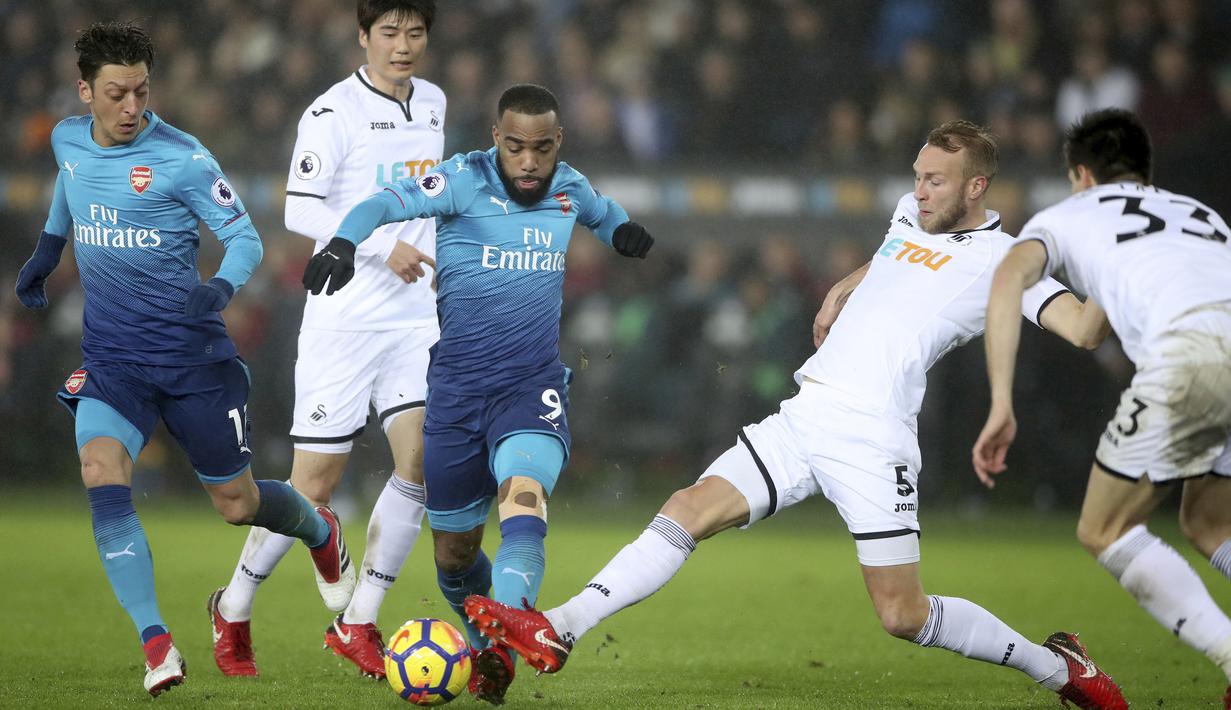 Aksi pemain Arsenal, Alexandre Lacazette melewati adangan pemain Swansea City, Mike van der Hoorn pada lanjutan Premier League di Liberty Stadium, Swansea, Wales, (30/1/2018). Arsenal kalah 1-3. (Nick Potts/PA via AP)