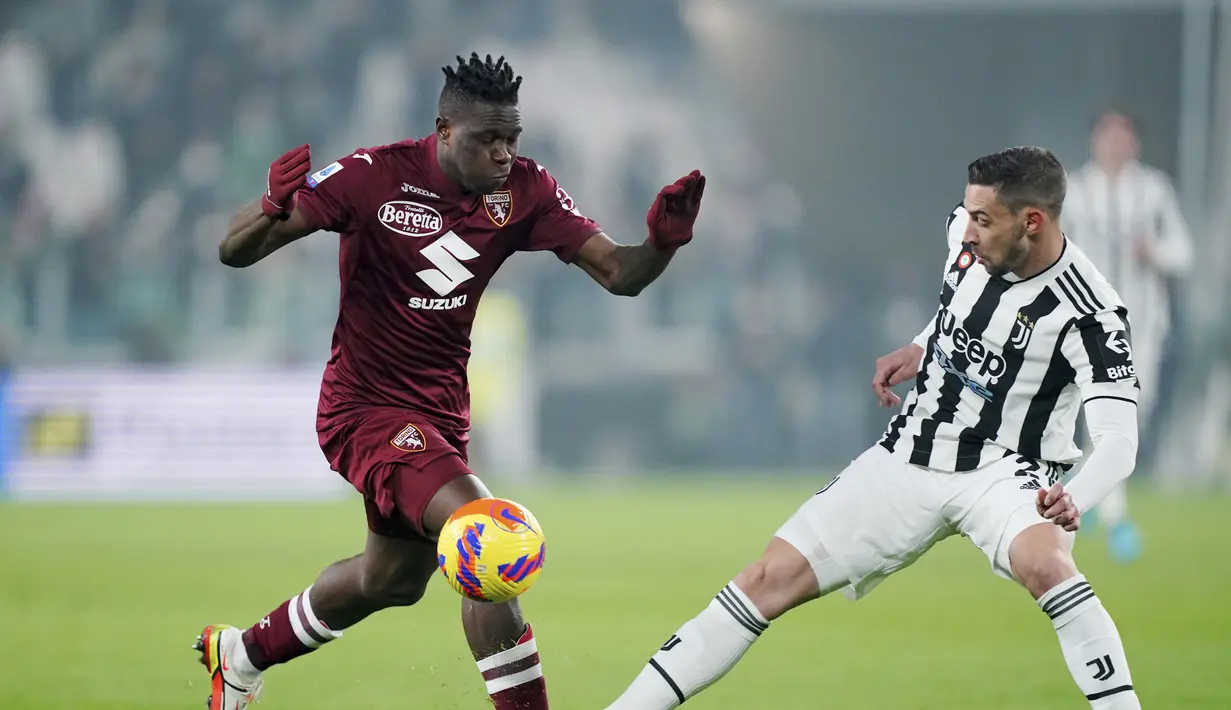 Bek Torino Wilfried Singo berebut bola dengan bek Juventus Mattia De Sciglio dalam pekan 26 Serie A Liga Italia di Allianz Stadium, Sabtu (19/2/2022) dinihari WIB. Juventus ditahan imbang Torino 1-1. (Spada/LaPresse via AP)